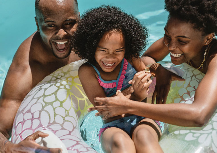 Child and parents playing in a pool