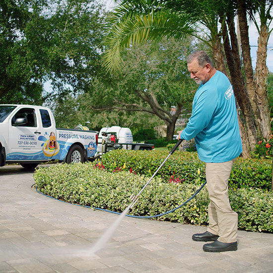 A man pressure washing a driveway