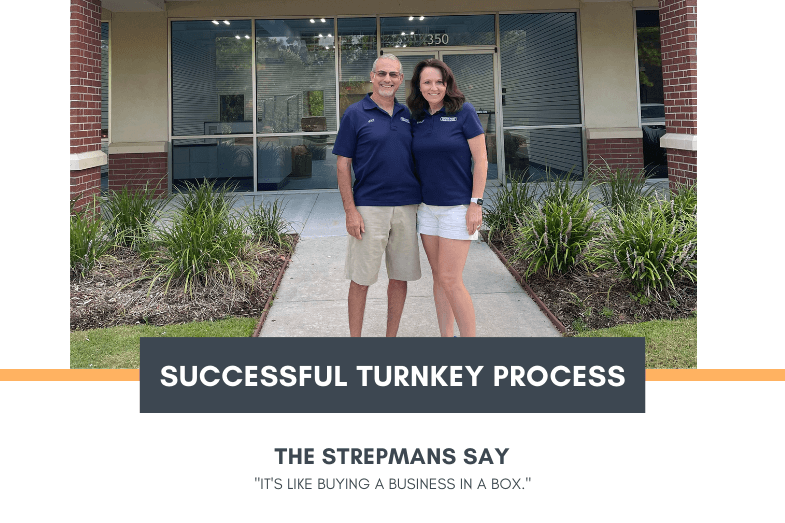 Franchise owners posing in front of their new store.