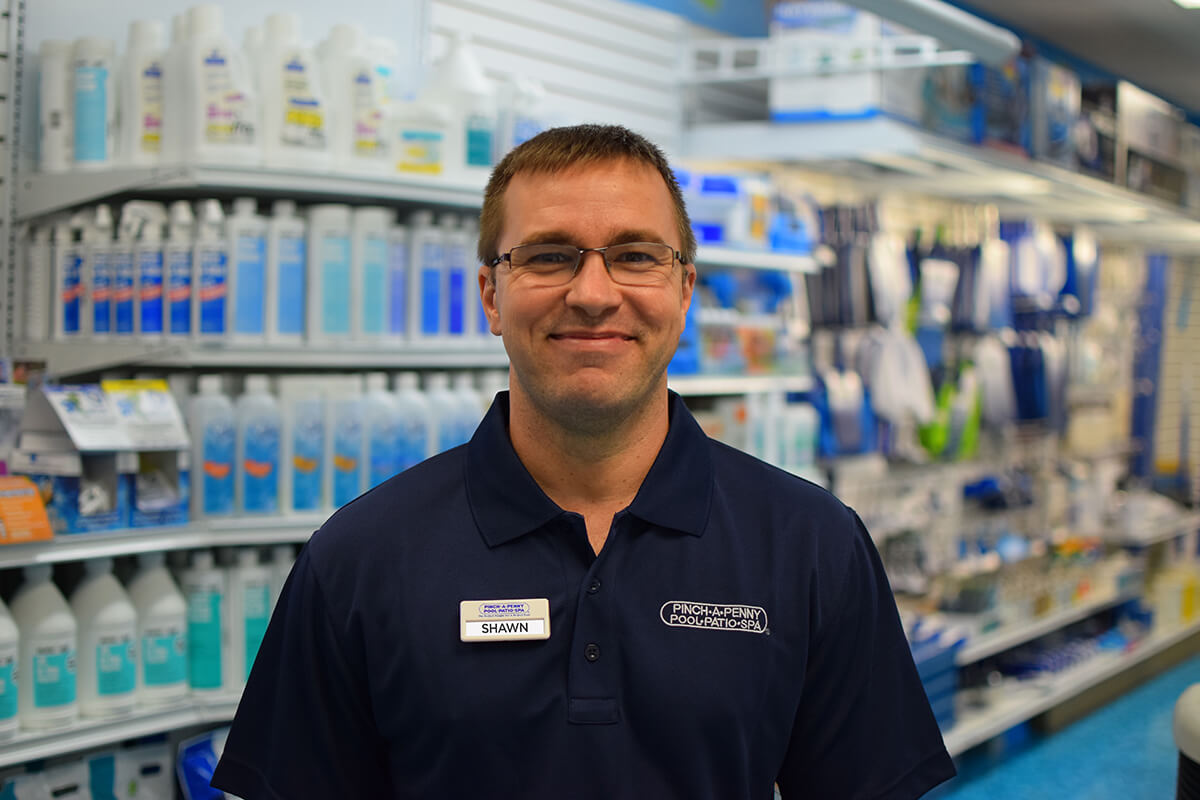 Employee smiling inside store aisle of pool supplies.