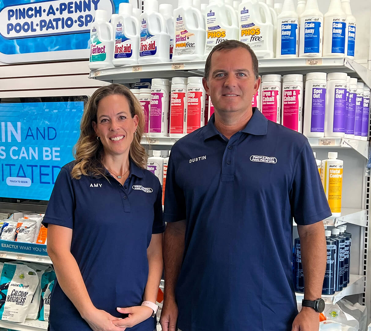 Franchise owners smiling together in front of store.