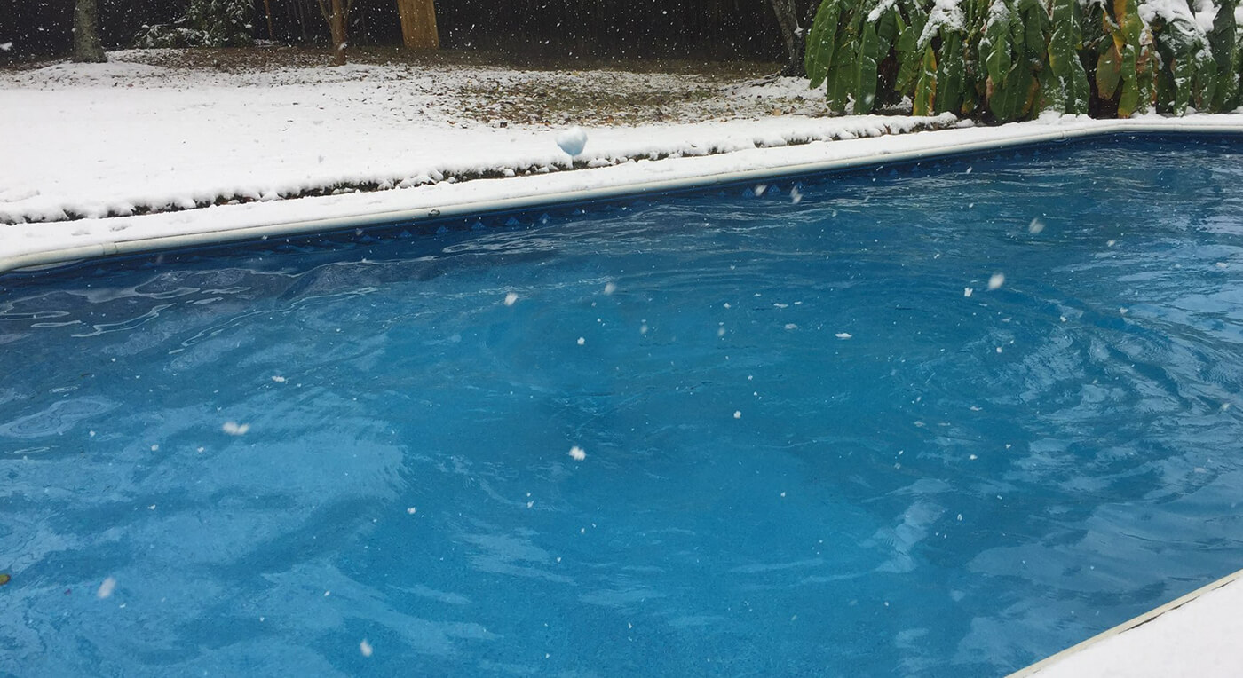 Photo of snowy backyard swimming pool.