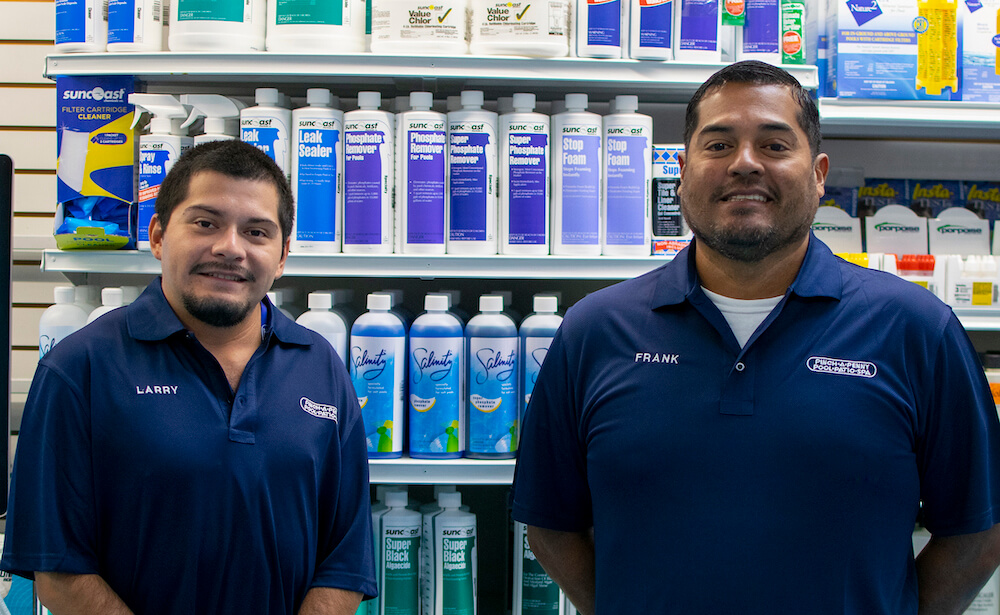 Two male employees posing inside Pinch A Penny store.