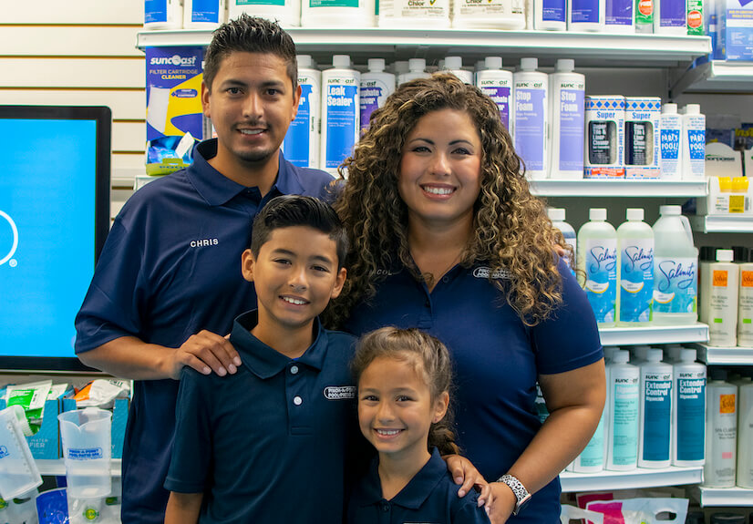 Franchise owner with family smiling together outside.