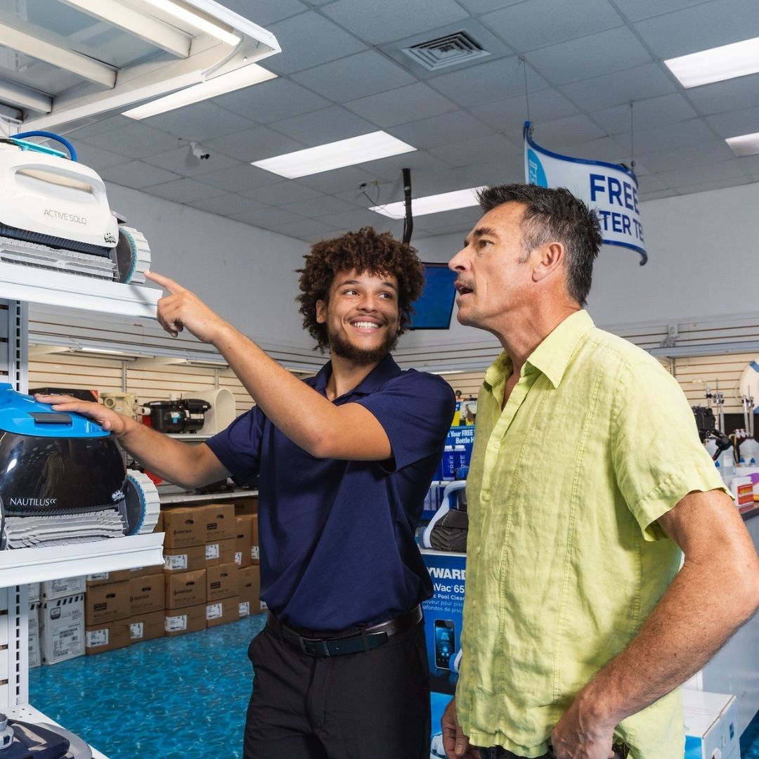 Pinch A Penny associate assisting a customer inside the store with pool equipment.